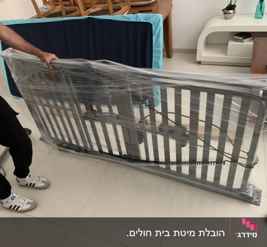 אדם אורז מיטה מתקפלת עם ניילון בחדר